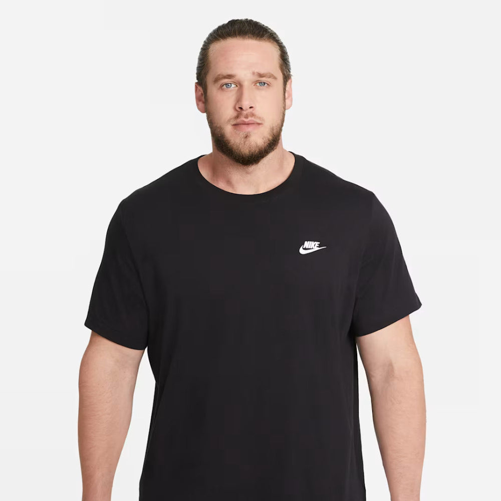 Man wearing a black Nike t-shirt with a white logo on a light gray background