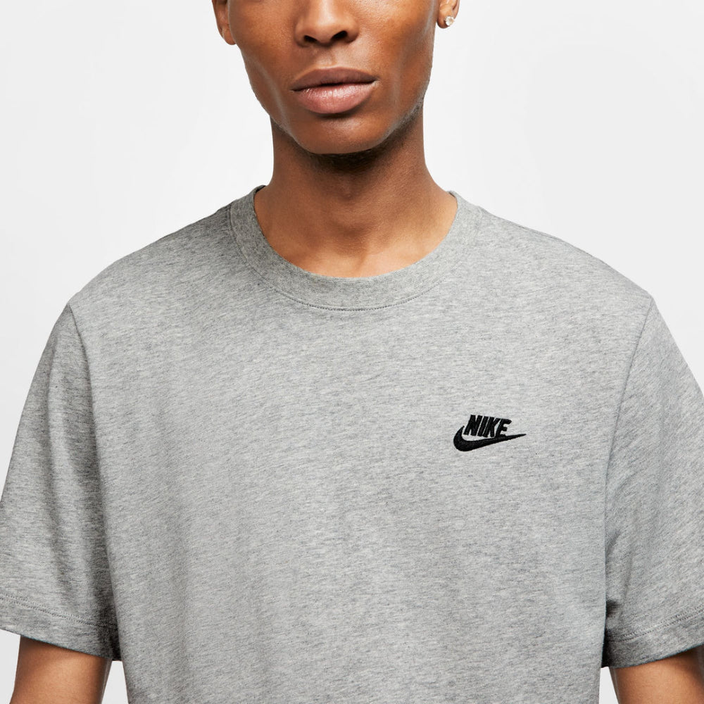 Person wearing a gray Nike t-shirt with a black logo on a light gray background