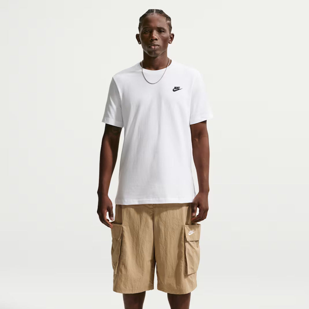 Person wearing a white Nike t-shirt and beige cargo shorts on a white background