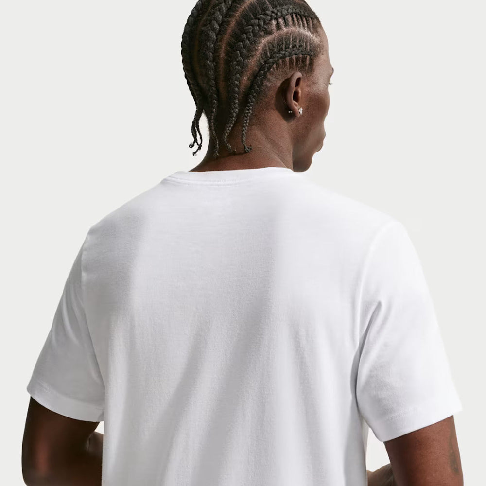 Person wearing a plain white t-shirt on a light gray background