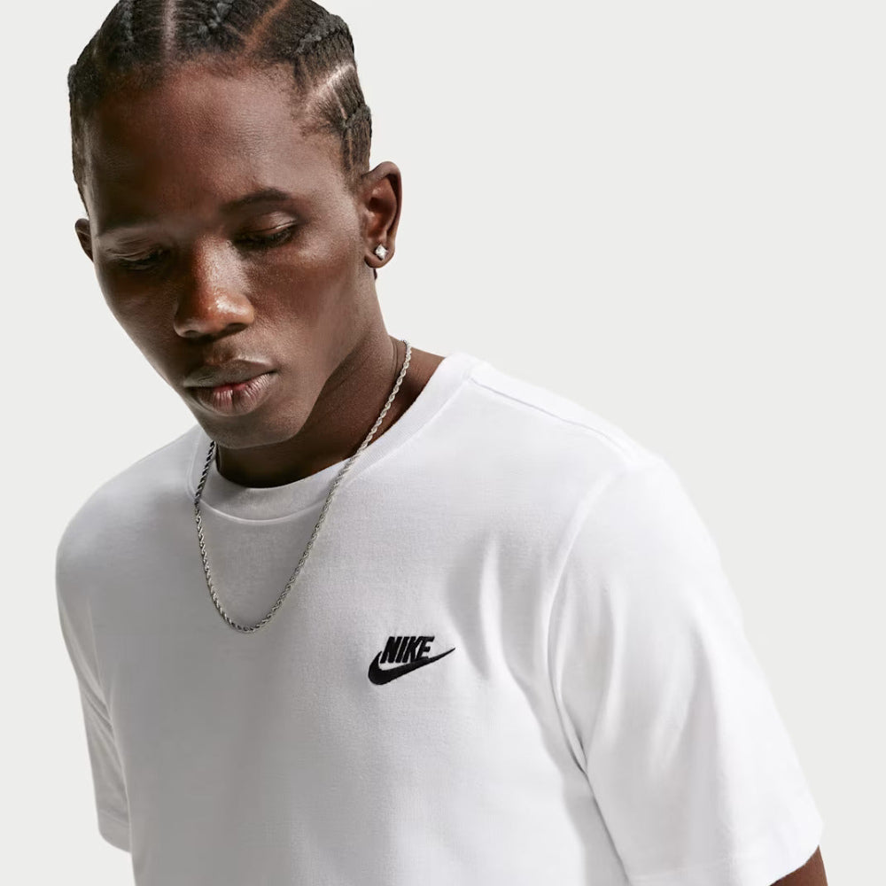 Person wearing a white Nike t-shirt on a light gray background